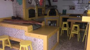 eine Küche mit einer Spielküche mit Hockern und einer Theke in der Unterkunft Mansão Bolsoni in Saquarema