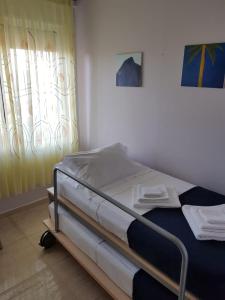 łóżko szpitalne w pokoju z oknem w obiekcie Main square apartment w Durrës
