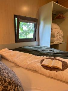 a bed with two books on it with a window at MAGNOLIA HOUSE by the RIVER XL in Metlika