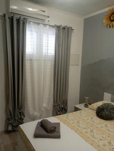a bedroom with a bed and a window with curtains at Pia Apartment in Dugi Rat