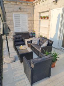 un patio con sofás, sillas y una mesa. en Villa Nobilo, en Lumbarda
