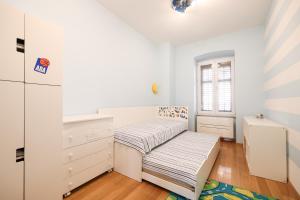 ein weißes Schlafzimmer mit einer Bank und einer Kommode in der Unterkunft Apartment Mislav in Zadar