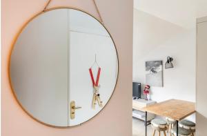 un espejo redondo colgado en una pared junto a una mesa en CHIC HUMARALET, estudio a pie de pistas, en Baqueira Beret