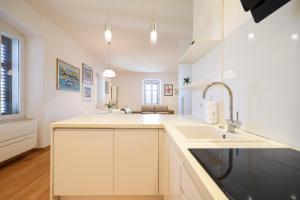eine Küche mit weißen Schränken und einer Spüle in der Unterkunft Apartment Mislav in Zadar + 37 Fotos