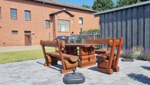 Beauty and Beast 24h-Check-in, 6 Pers, Klima, Massageliege في Cremlingen: طاولة وكراسي خشبية على فناء