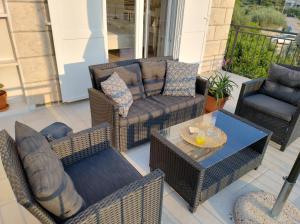 un patio con muebles de mimbre, mesa y sillas en Villa Nobilo, en Lumbarda