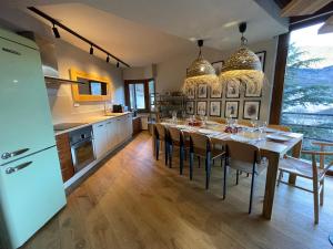 uma cozinha e sala de jantar com mesa e cadeiras em Tuca - Triplex Priviletge con encanto em Vielha