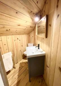 uma casa de banho em madeira com um lavatório e um espelho em Tuca - Triplex Priviletge con encanto em Vielha