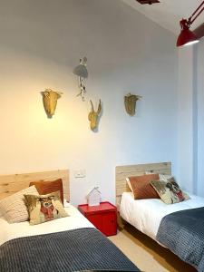 1 dormitorio con 2 camas y cabeza de imal en la pared en Tuca - Triplex Priviletge con encanto, en Vielha