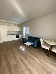 a living room with a blue couch and a table at Lustica Bay Centrale Sparcle in Tivat