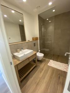a bathroom with a sink and a toilet and a mirror at Lustica Bay Centrale Sparcle in Tivat +21 photos