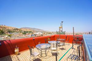 a patio with tables and chairs on a balcony at Riad Sahraui in Fez