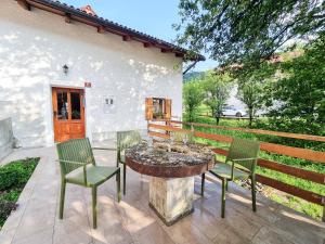 un patio con sillas y una mesa con una fuente. en Country House Lastovka, en Tolmin