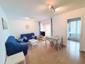 - un salon avec un canapé bleu et une table dans l'établissement PLAYA PONIENTE, COBLANCA XVI (A 200m DE LA PLAYA), à Benidorm
