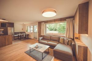 un soggiorno con divano e tavolo di Apartment Gipfelblick a Kirchdorf in Tirol
