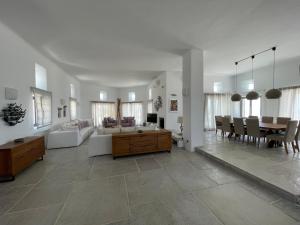 un ampio soggiorno con tavolo e divano di Villa Faros a Fanari