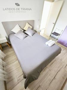 セビリアにあるLatidos de Triana - Apartamento en Triana totalmente equipadoのベッドルーム1室(大型ベッド1台、白いシーツ、枕付)