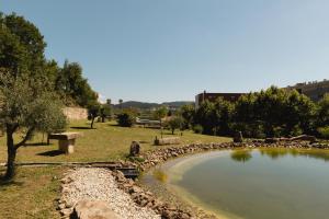 un parc avec une masse d'eau et un étang dans l'établissement Quinta dos Tojais, à Castelbuono