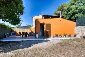 een klein geel huis met een tafel en stoelen bij La Casina di Alan - Goelba in Porto Azzurro