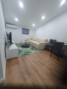 a living room with a couch and a table and chairs at MB Apartman in Čapljina