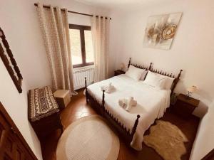 um quarto com uma cama com lençóis brancos e uma janela em Casa Brian del Tietar em Sotillo de la Adrada