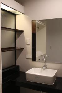 a bathroom with a sink and a mirror at Be-ing Suites in Davao City