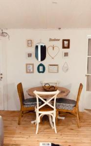einen Tisch und Stühle in einem Zimmer mit einer Wand mit Bildern in der Unterkunft APARTAMENTO CON ENCANTO TÍPICO CERETÀ Centro in Puigcerdà