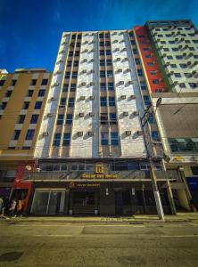 een hoog gebouw in een stadsstraat met gebouwen bij César Inn Juiz de Fora Hotel in Juiz de Fora