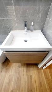 a white sink in a bathroom with a wooden floor at Appart douillet hypercentre neuf climatisé in Valence