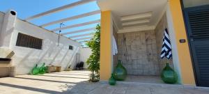a group of green vases sitting on the side of a building at Villa PARADISO - Tra Ulivi e Tramonti da Cartolina in Muro Leccese