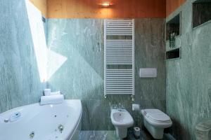 La salle de bains est pourvue d'une baignoire, de toilettes et d'un lavabo. dans l'établissement REVO Apartments - Santa Barbara1, à Bormio
