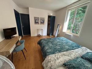 a bedroom with a bed and a desk and a television at Appartement confortable de 80m2 Centre ville de Quimper & Parking privé in Quimper
