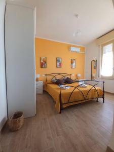 a bedroom with a bed and yellow walls at Divina Cuspide in Guspini