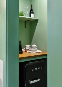 a kitchen with a black dishwasher and a shelf with wine bottles at Le Petit Pali at Ocean Ave in Carmel