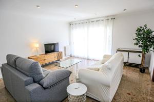 a living room with a couch and a chair and a tv at LITORAL COSTA DORADA - AQUARIUM Only families in Cambrils