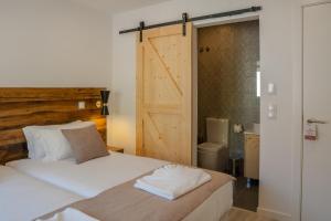 um quarto com uma cama com uma porta deslizante de celeiro em Casa Dona Maria em Montargil