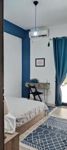 a bedroom with a bed and a blue wall at Beautiful Apartment in Corfu in Agios Rokkos