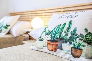a pillow on a bed with plants on it at LITORAL COSTA DORADA - AQUARIUM Only families in Cambrils