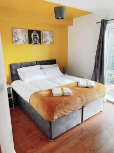 een slaapkamer met een groot bed en 2 handdoeken bij 2 Bed Apartment with Free Parking in Chelmsford
