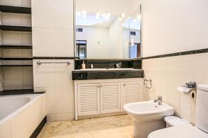 a bathroom with a sink toilet and a mirror at LITORAL COSTA DORADA - AQUARIUM Only families in Cambrils +42 photos