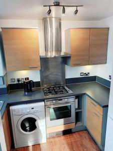 a kitchen with a stove and a washing machine at 2 Bed Apartment with Free Parking in Chelmsford
