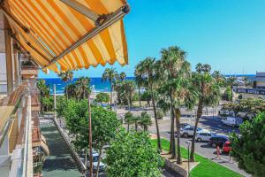a view of a street with palm trees and the ocean at LITORAL COSTA DORADA - AQUARIUM Only families in Cambrils