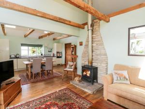 a living room with a fireplace and a couch and a table at Little Barn in Chippenham