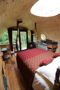 a bedroom with a large bed in a cabin at Caban Delor. Off-grid glamping experience. Walking distance into Caernarfon. 20-min drive to Snowdonia or Anglesey. in Caernarfon