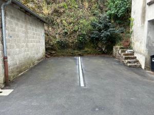an empty parking lot next to a brick wall at Appartement confortable de 80m2 Centre ville de Quimper & Parking privé in Quimper +3 photos