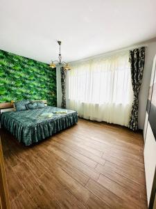 a bedroom with a bed with a green wall at Apartament lux Albert in Olimp