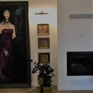a painting of a woman on a wall next to a fireplace at Historic house residence in Vilnius
