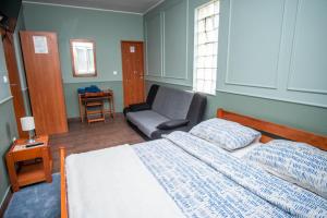 ein Schlafzimmer mit einem Bett und einem Stuhl in der Unterkunft Sobe Amadeus in Sesvete