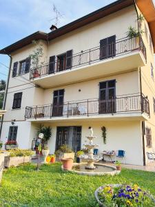 een groot wit gebouw met balkons en een tuin bij La casa del Tiglio in Sarzana