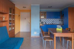 eine Küche mit blauen Schränken sowie einem Tisch und Stühlen in der Unterkunft la petit maisonette de manu in Cannes